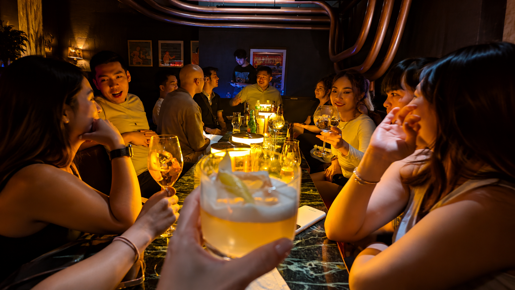 Guests hosted around the bar, drinks in hand, mid-conversation